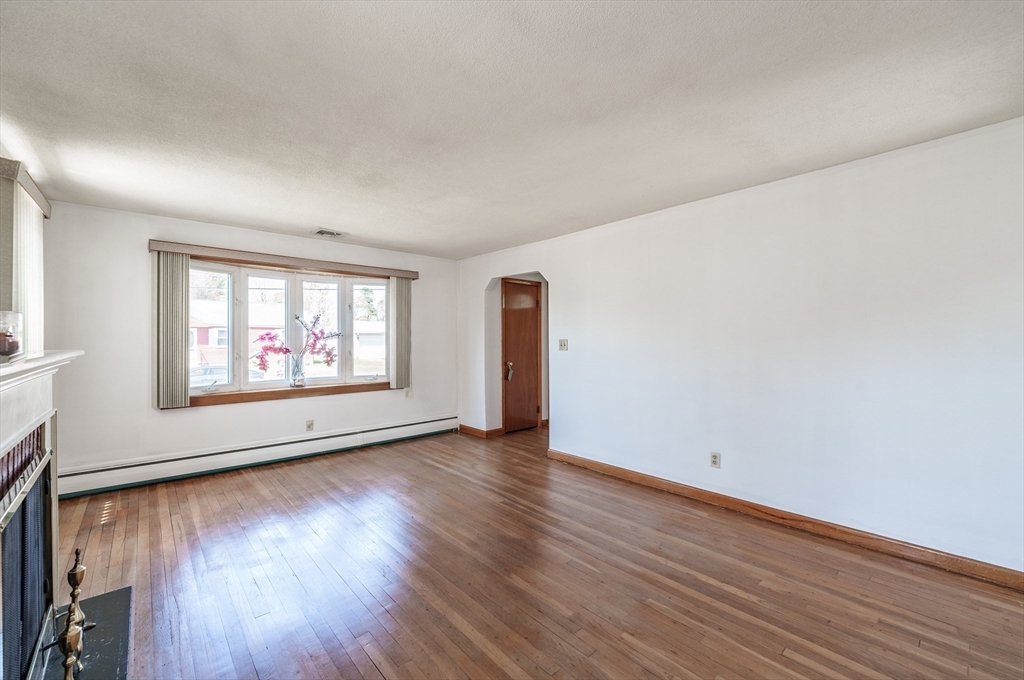 127 Cheyenne Road Springfield, MA 01109 - Photo 9 of 42 an empty room with wooden floor and windows
