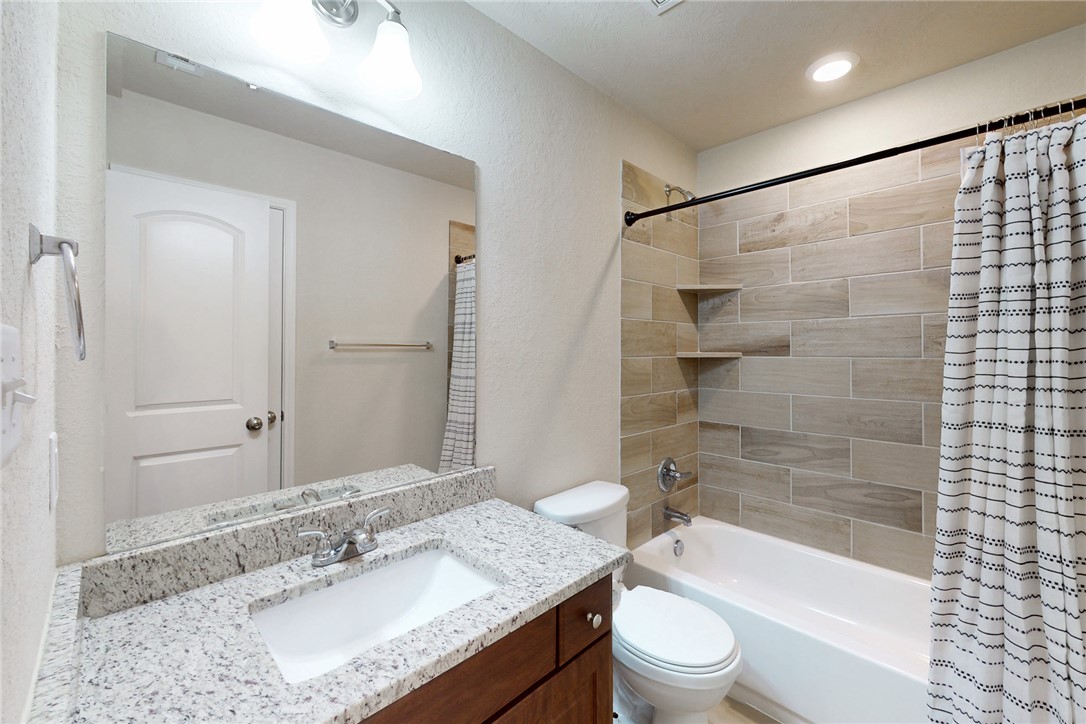 2101 Polmont Drive Bryan, TX 77807 - Photo 22 of 44 a bathroom with a granite countertop sink toilet tub and shower