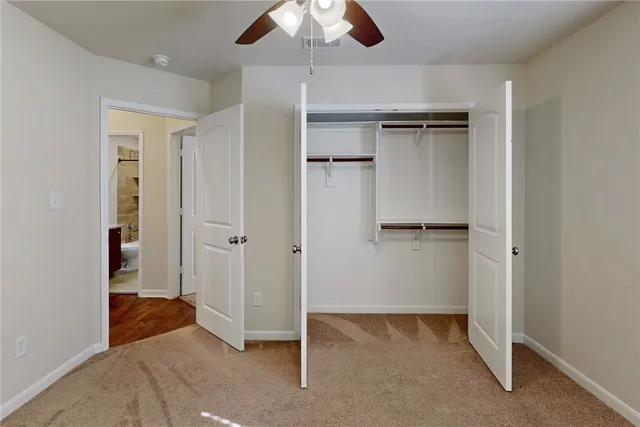 an empty room with window and ceiling fan