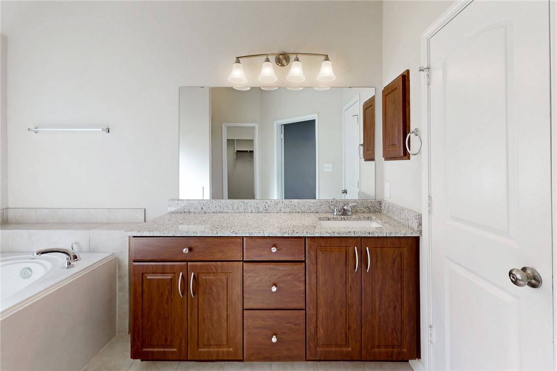 2101 Polmont Drive Bryan, TX 77807 - Photo 34 of 44 a bathroom with a granite countertop sink and a mirror