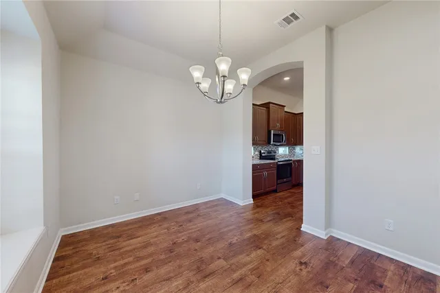 a view of a kitchen with wooden floor and a window