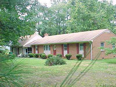 a view of a house with a yard and potted plants