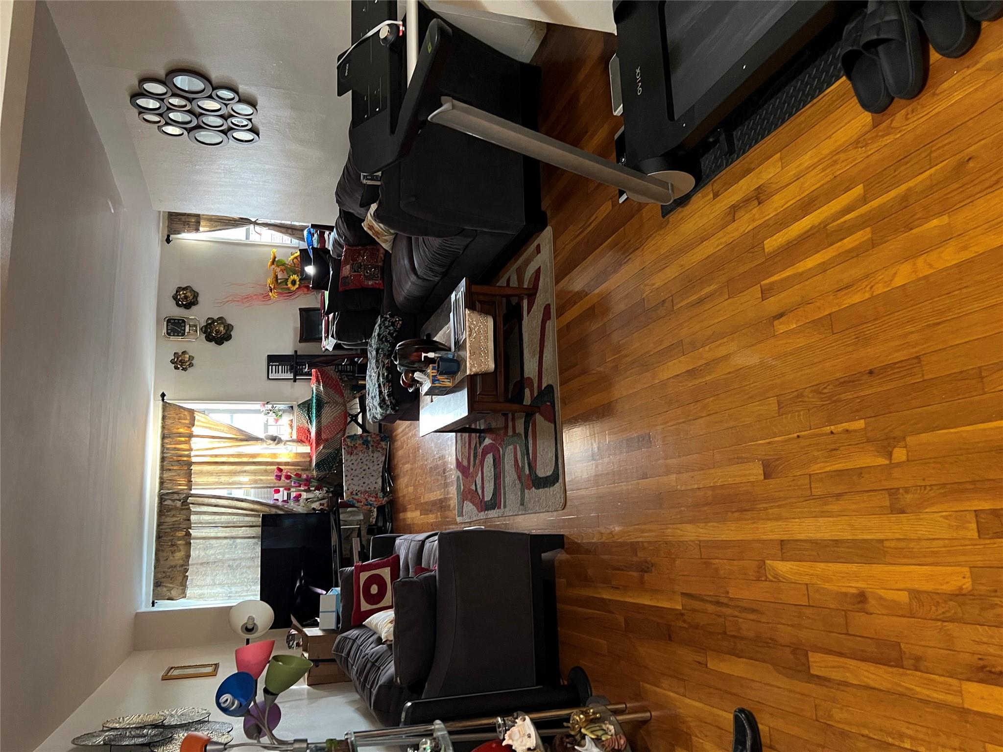 55-30 99th Street, Unit 2H Queens, NY 11368 - Photo 5 of 19 a living room with furniture and a flat screen tv