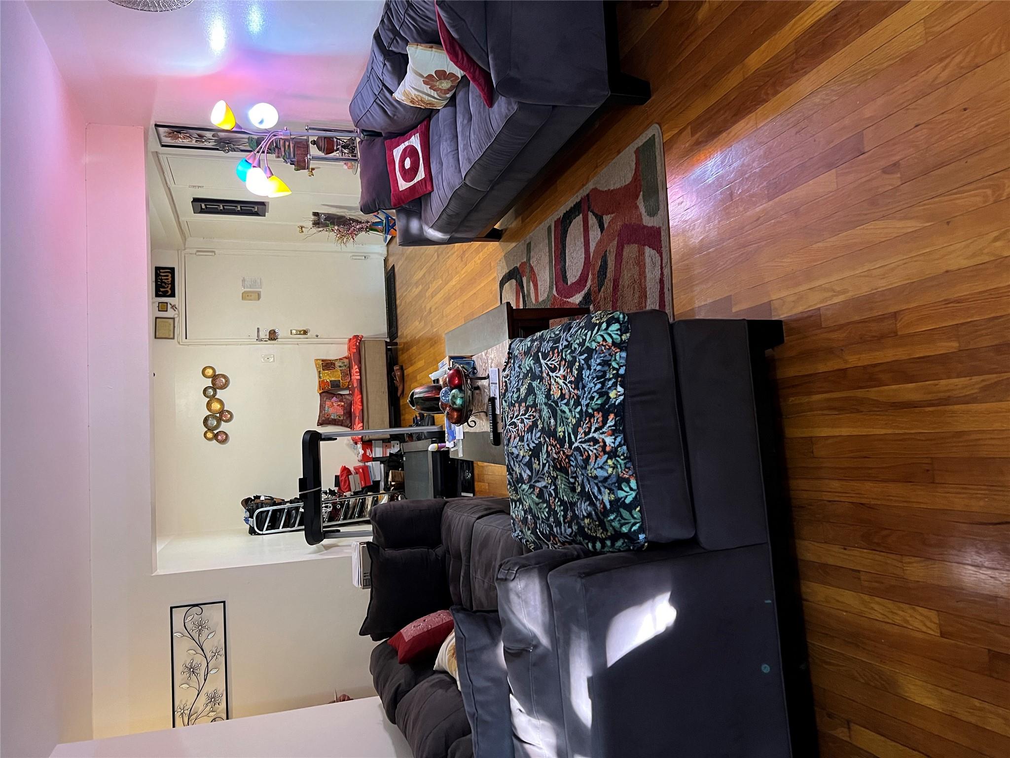 55-30 99th Street, Unit 2H Queens, NY 11368 - Photo 7 of 19 a living room with furniture and wooden floor