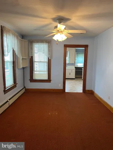 a view of a big room with windows and chandelier fan