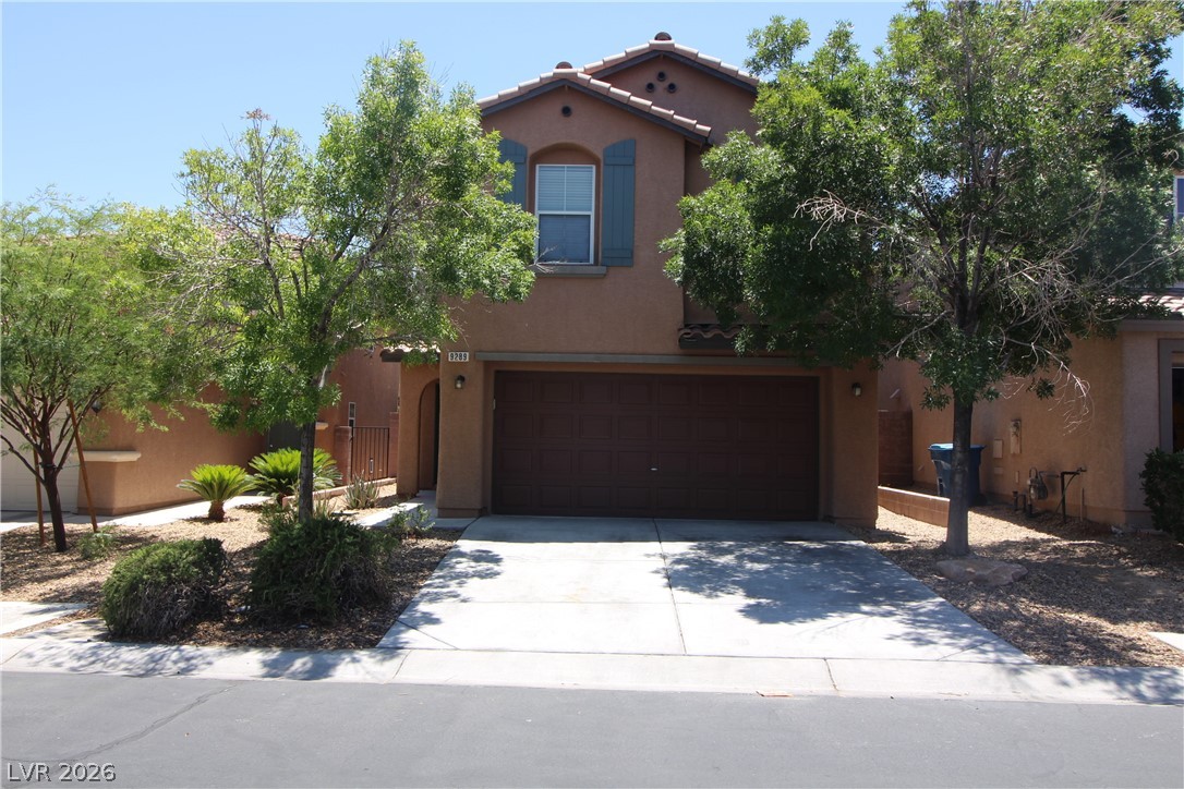 A well-maintained stucco facade with an integrated garage provides inviting curb appeal.