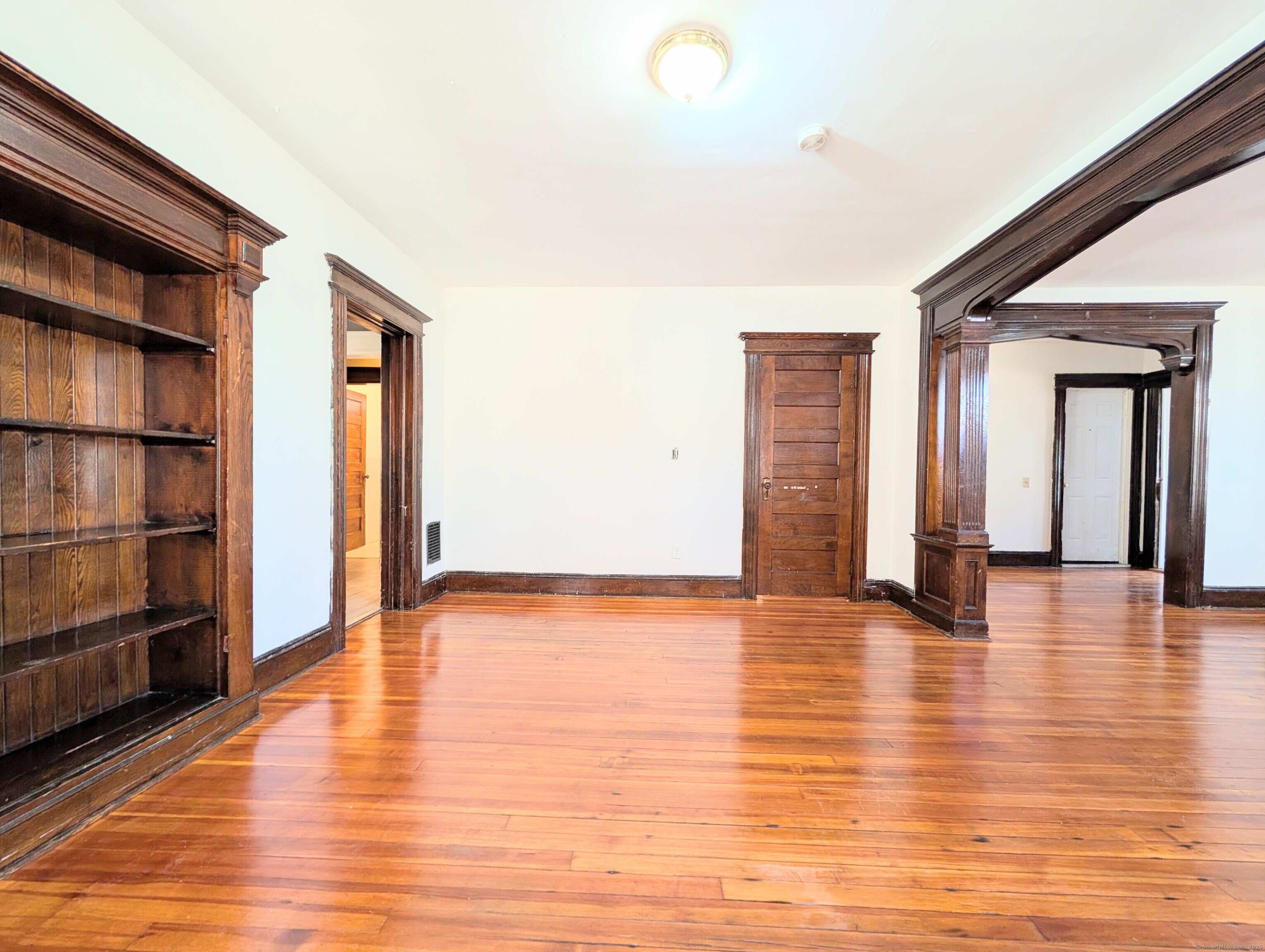 133 Poplar Street Bridgeport, CT 06605 - Photo 13 of 36 a view of an empty room with wooden floor and a window
