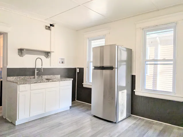 a kitchen with kitchen island a sink stove and refrigerator