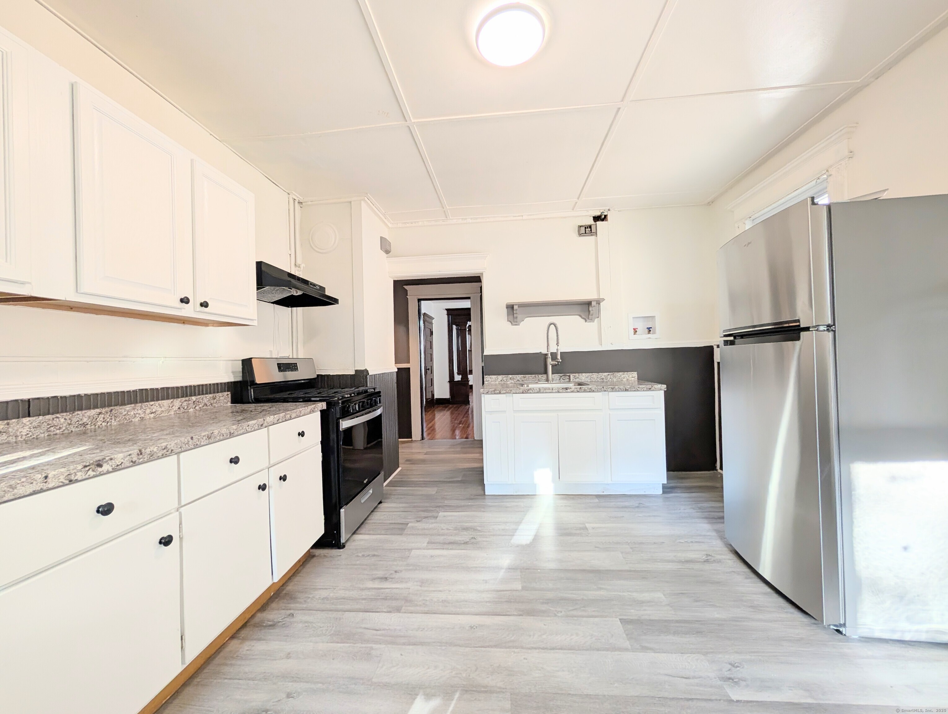 133 Poplar Street Bridgeport, CT 06605 - Photo 19 of 36 a large kitchen with stainless steel appliances and white cabinets