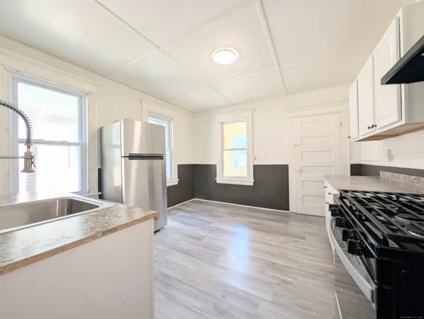 a kitchen with granite countertop a sink stove and refrigerator