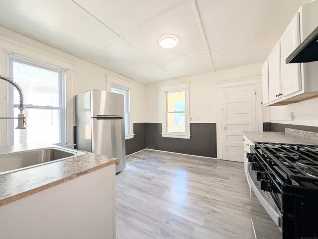 a kitchen with granite countertop a sink stove and refrigerator