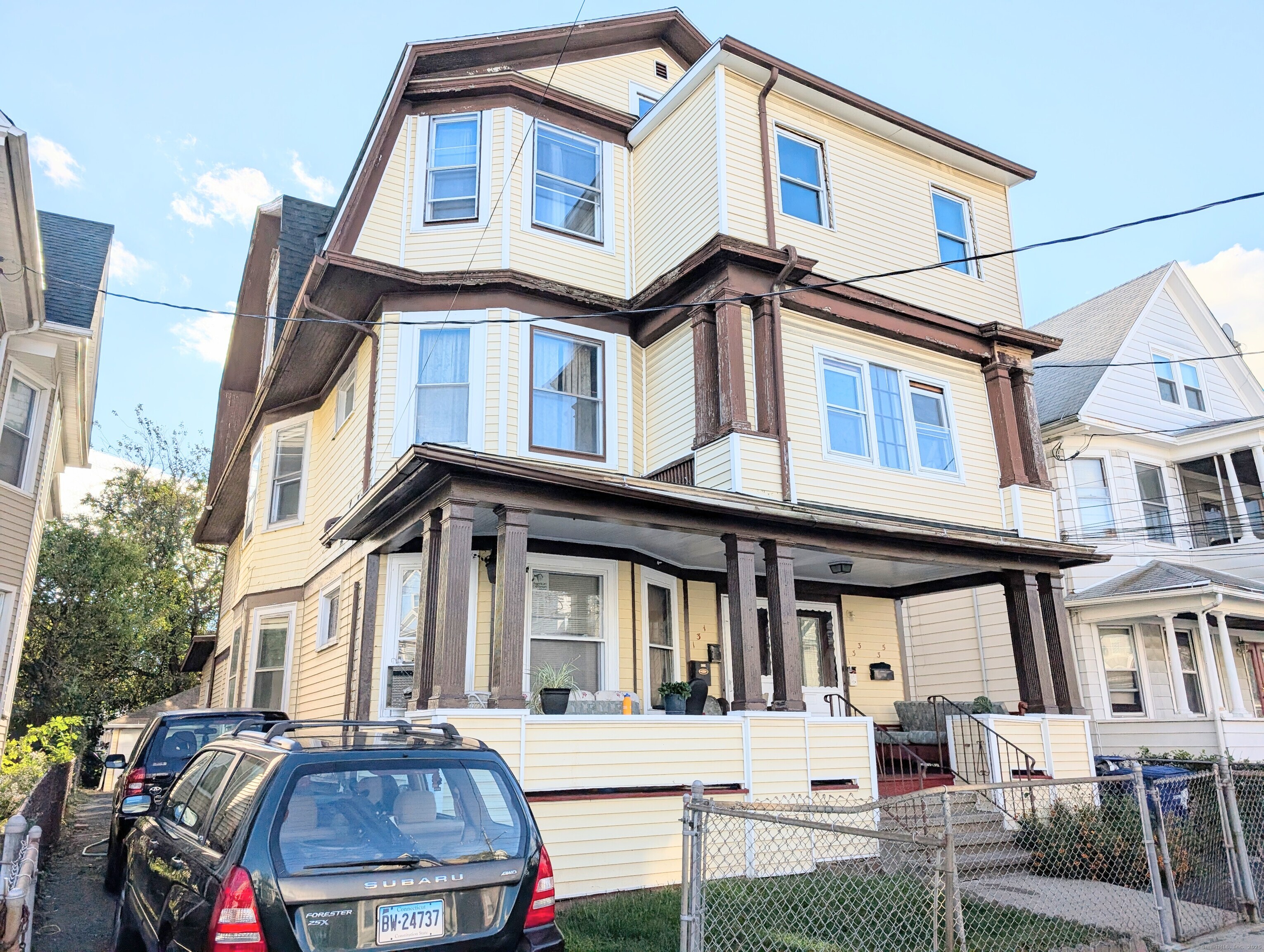 133 Poplar Street Bridgeport, CT 06605 - Photo 2 of 36 a front view of a residential apartment building with a yard