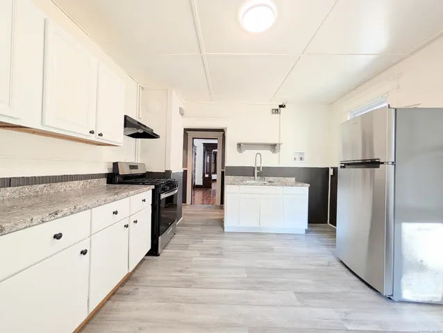 a large kitchen with stainless steel appliances and white cabinets