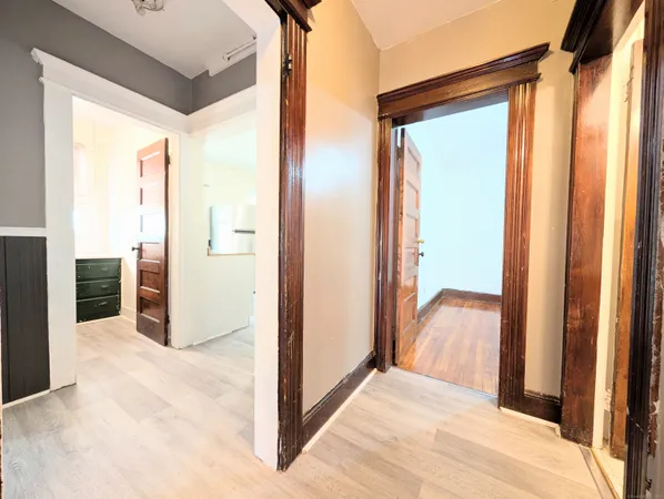 a view of a hallway with wooden floor and closet