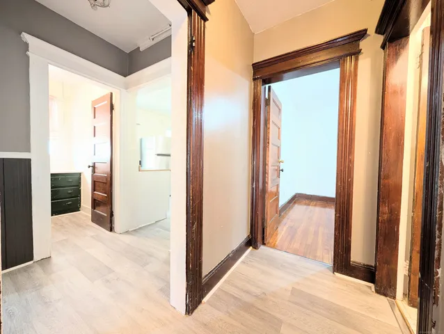 a view of a hallway with wooden floor and closet