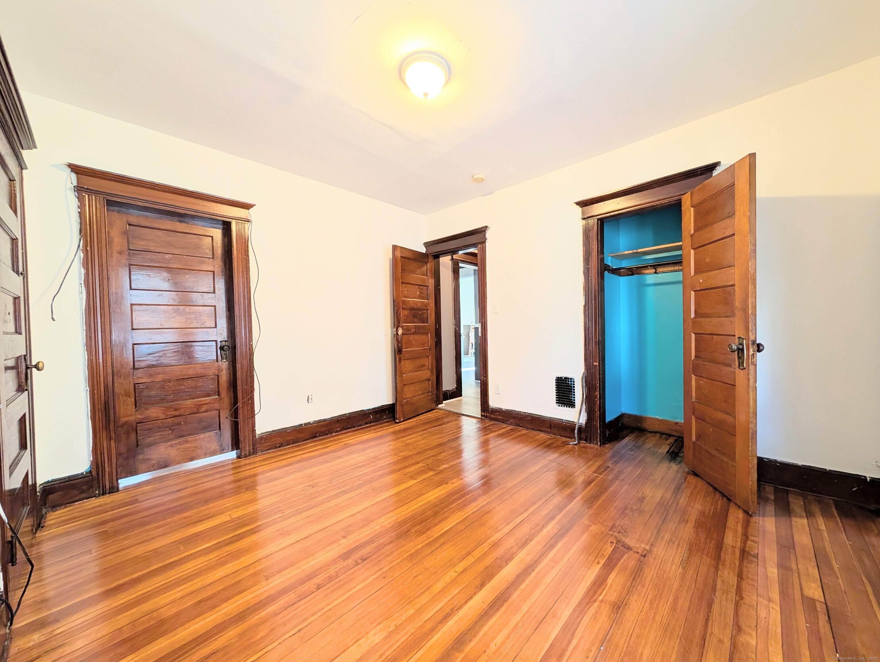 133 Poplar Street Bridgeport, CT 06605 - Photo 36 of 36 an empty room with wooden floor and closet