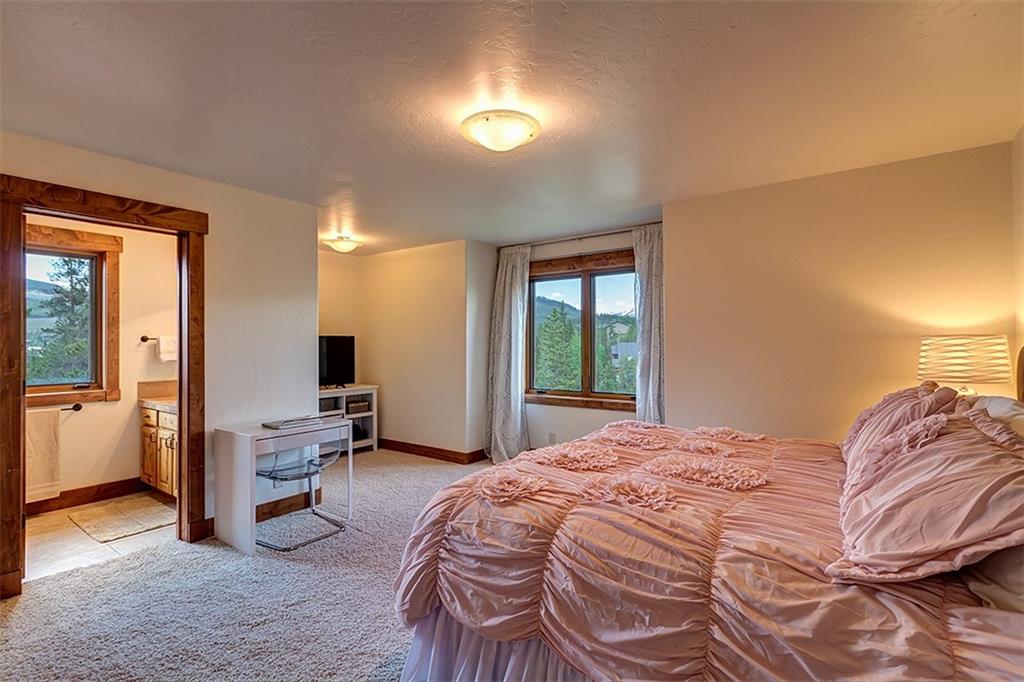22 Braddock Drive Breckenridge, CO 80424 - Photo 27 of 35 a bedroom with a bed and a chandelier