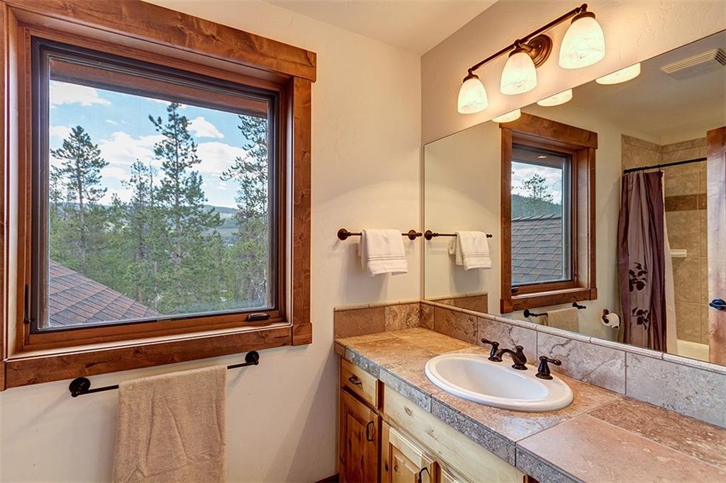 22 Braddock Drive Breckenridge, CO 80424 - Photo 29 of 35 a bathroom with a granite countertop sink a mirror and a shower