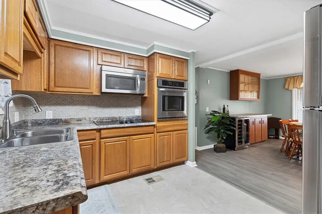 a kitchen with stainless steel appliances granite countertop a sink stove and cabinets