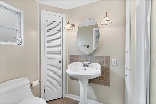 a bathroom with a sink toilet and mirror