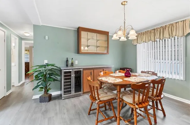 a dining room with furniture potted plants and wooden floor