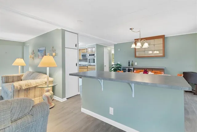a living room with a couch and a dining table with wooden floor