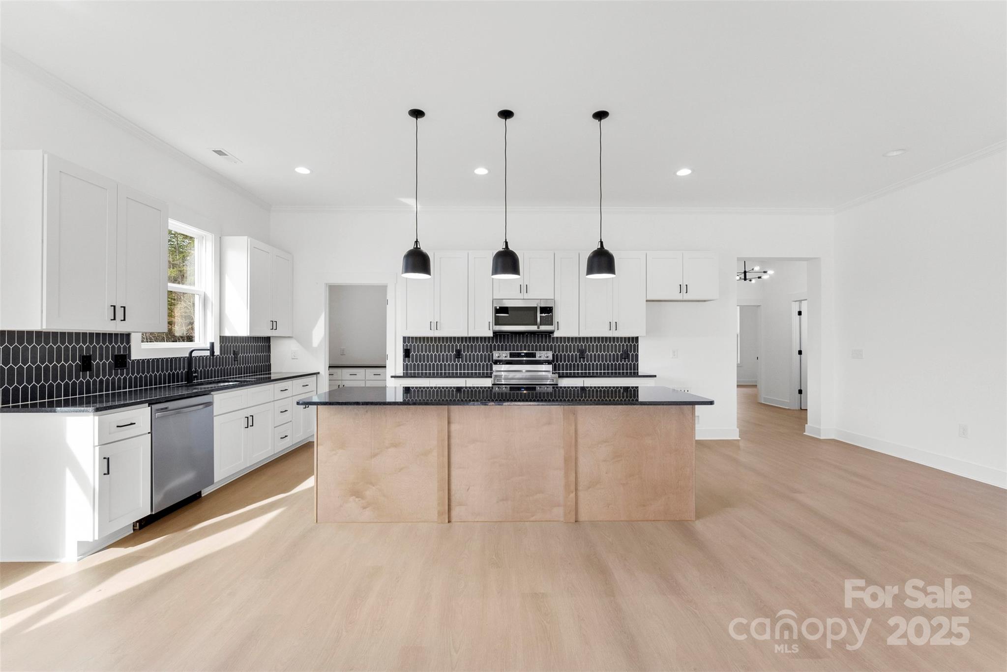 4085 Miller Road Salisbury, NC 28147 - Photo 13 of 46 a large kitchen with granite countertop a white stove top oven a sink and white cabinets