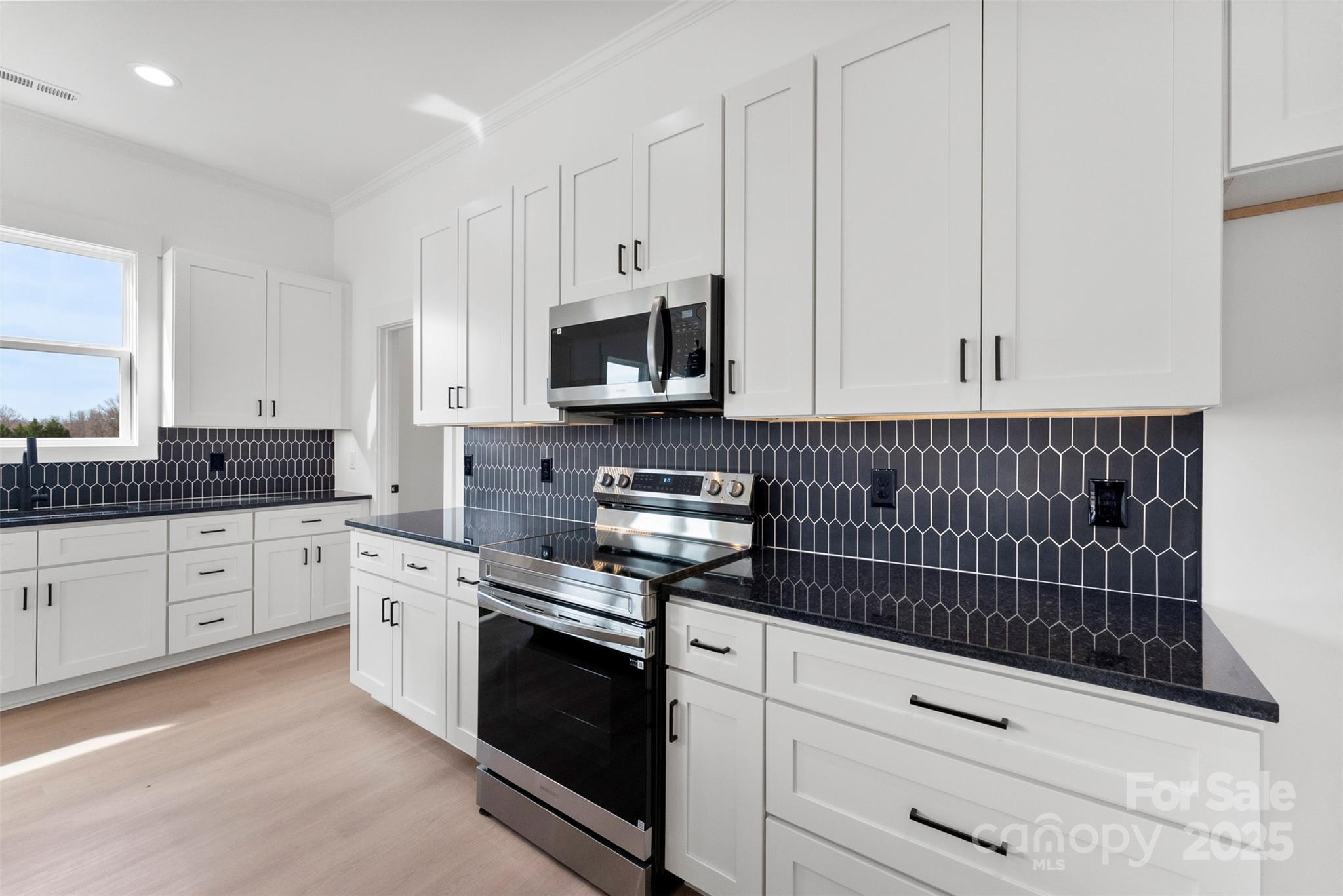 4085 Miller Road Salisbury, NC 28147 - Photo 8 of 46 a kitchen with granite countertop white cabinets stainless steel appliances and sink