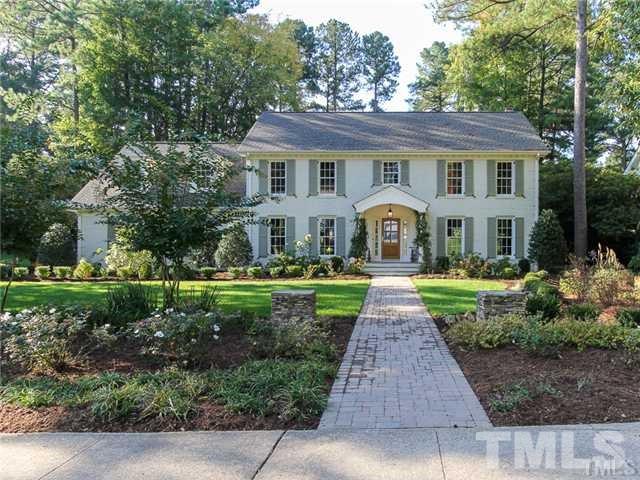 a front view of a house with yard and green space