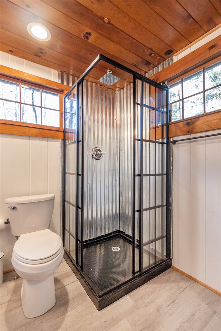 205 Rocky Bottom Road Sunset, SC 29685 - Photo 19 of 46 Rich wood plank ceilings and a corrugated metal shower define this rustic bathroom space.