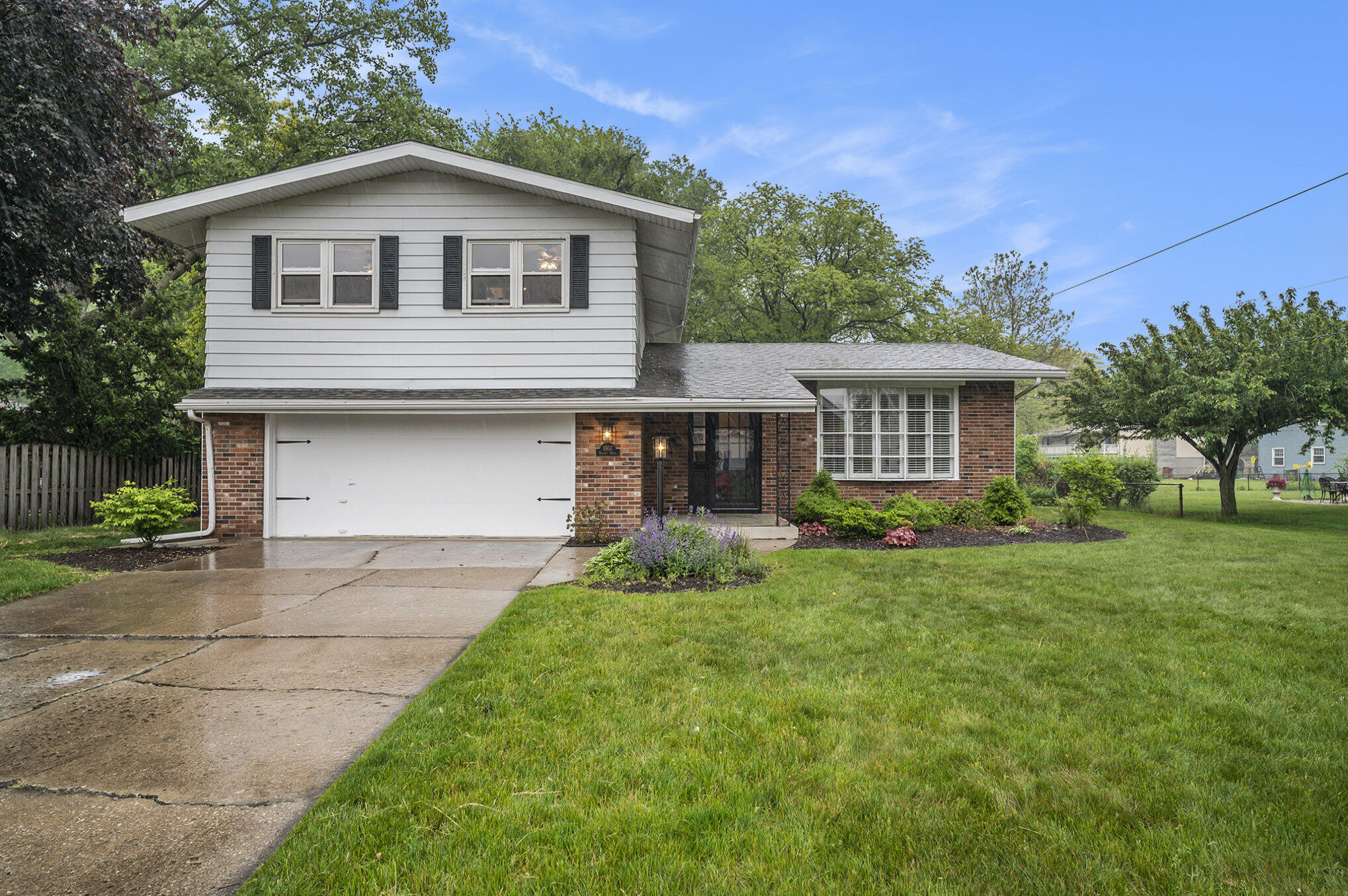 9307 Walnut Drive Munster, IN 46321 - Photo 2 of 26 a front view of a house with a yard and garage