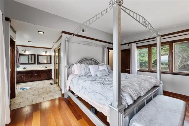 a bedroom with a large bed and wooden floor