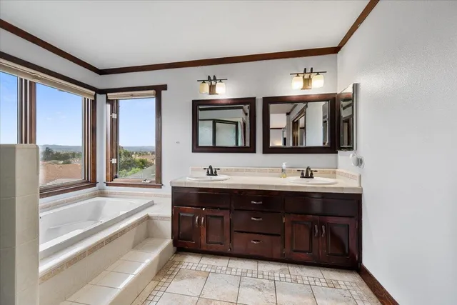 a bathroom with a tub sink and mirror