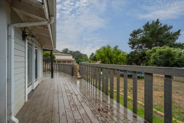 a balcony with wooden floor and wooden fence