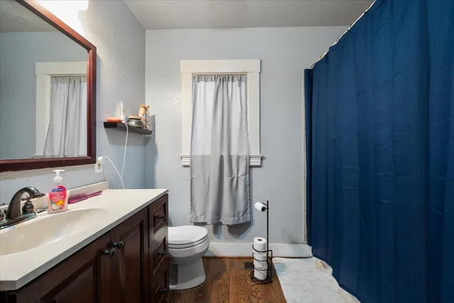 a bathroom with a sink vanity granite and toilet