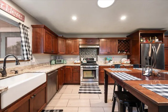 a kitchen with stainless steel appliances granite countertop a sink stove and refrigerator