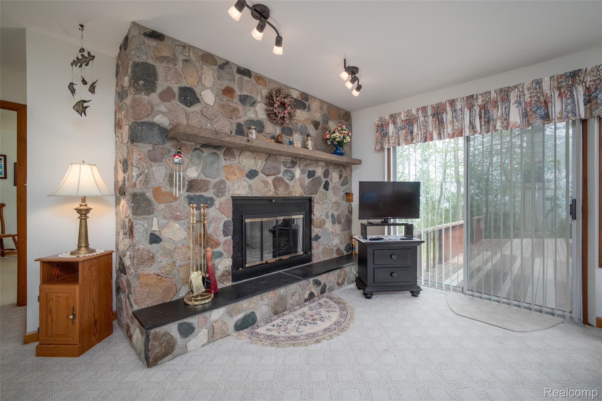 6240 Lakeshore Road Palms, MI 48465 - Photo 6 of 38 Living area with a stone fireplace and carpet floors