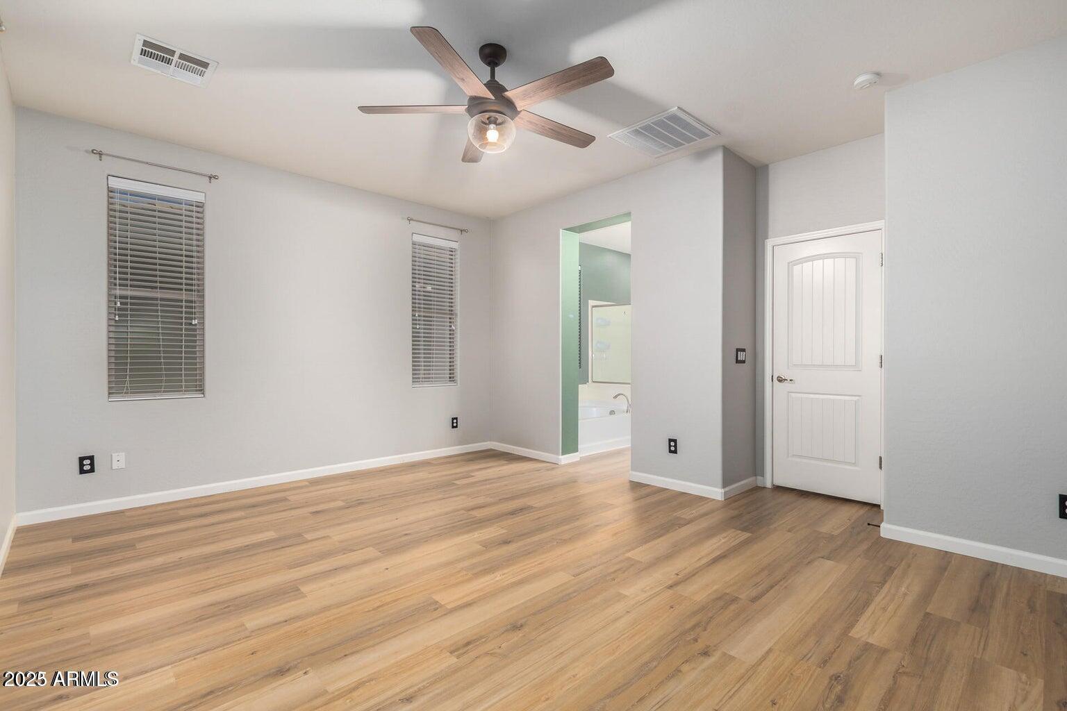4674 South Twinleaf Drive Gilbert, AZ 85297 - Photo 7 of 18 a view of an empty room with wooden floor and a window