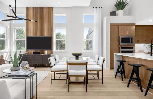 a living room with furniture large window and wooden floor
