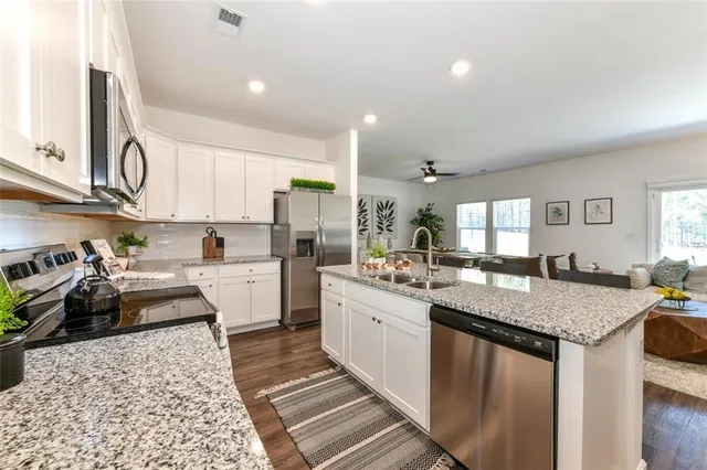 a kitchen with granite countertop a sink stove and cabinets