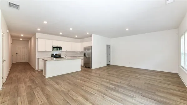 a view of kitchen with kitchen island white cabinets wooden floor and center island