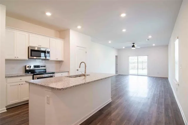 a kitchen with appliances a sink cabinets and wooden floor
