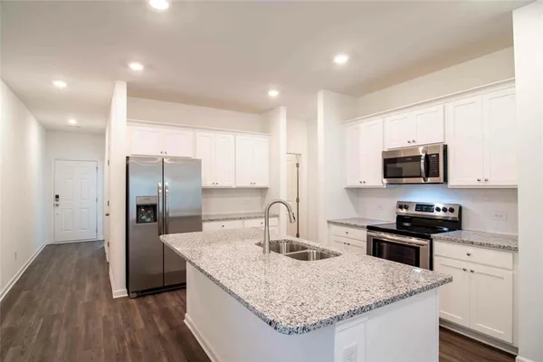 a kitchen with stainless steel appliances granite countertop a sink stove and refrigerator