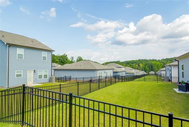 a view of a white house with a swimming pool and a yard