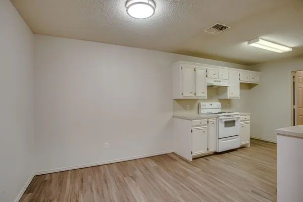 a kitchen with white cabinets and white appliances