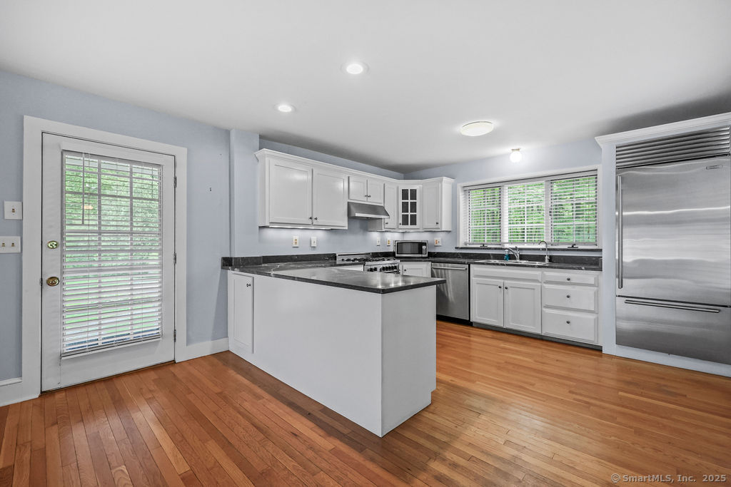 88 Powder Hill Road Middlefield, CT 06455 - Photo 18 of 40 a kitchen with granite countertop wooden floors stainless steel appliances and window