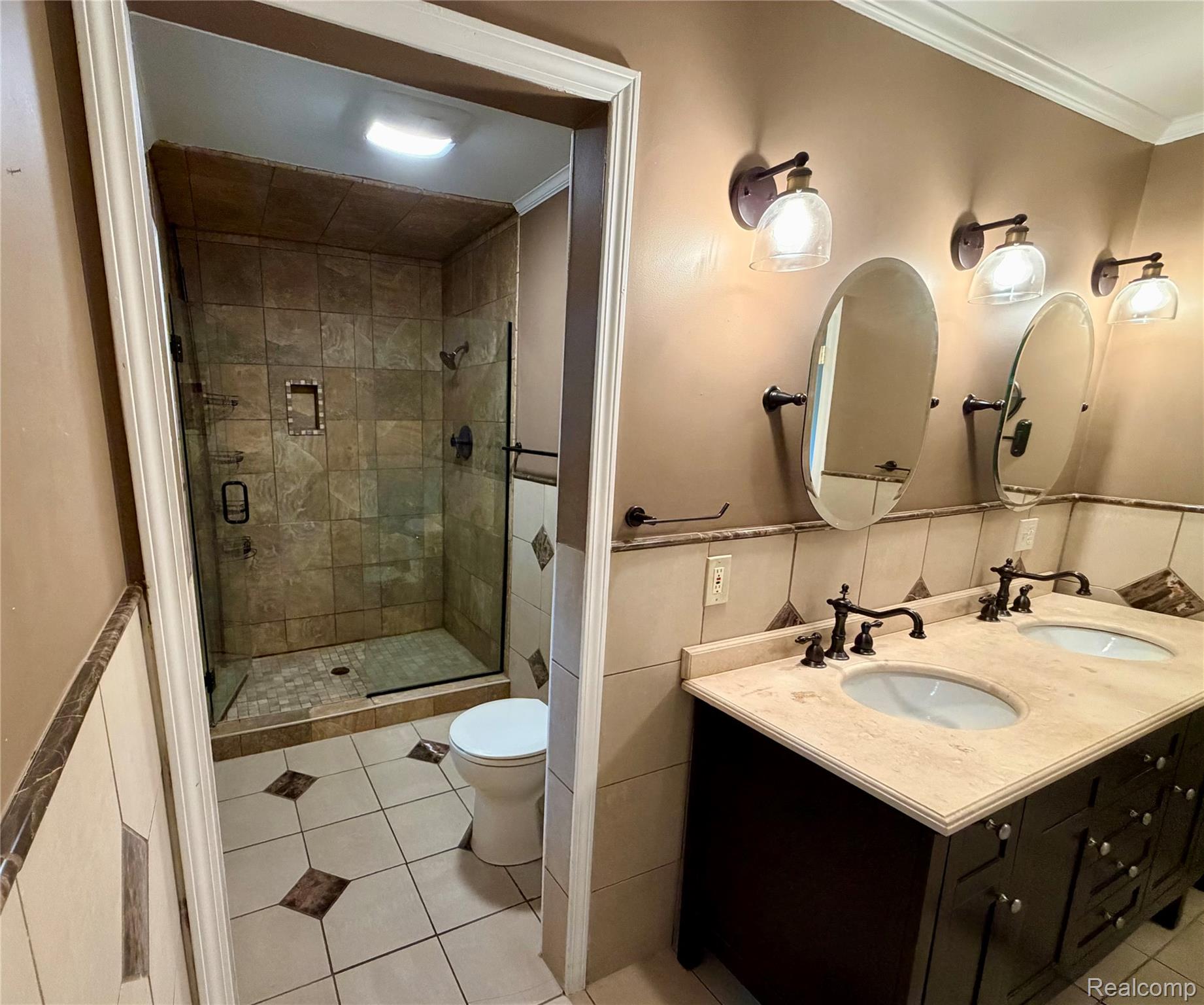 10280 Nimphie Road Fenton, MI 48430 - Photo 13 of 30 Double vanity with undermount sinks and dark bronze fixtures, tile backsplash, and two wall-mounted mirrors