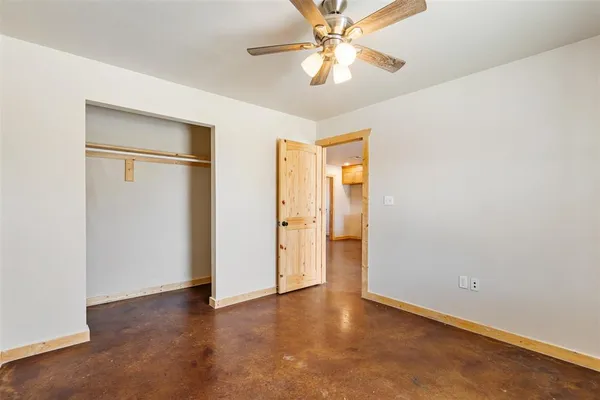 an empty room with a ceiling fan and a gallery