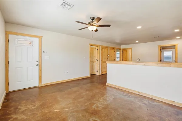 a view of a livingroom with a ceiling fan window and kitchen view