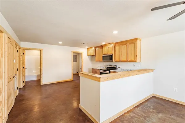 a kitchen with stainless steel appliances a stove a refrigerator a sink a refrigerator with white cabinets and wooden floor